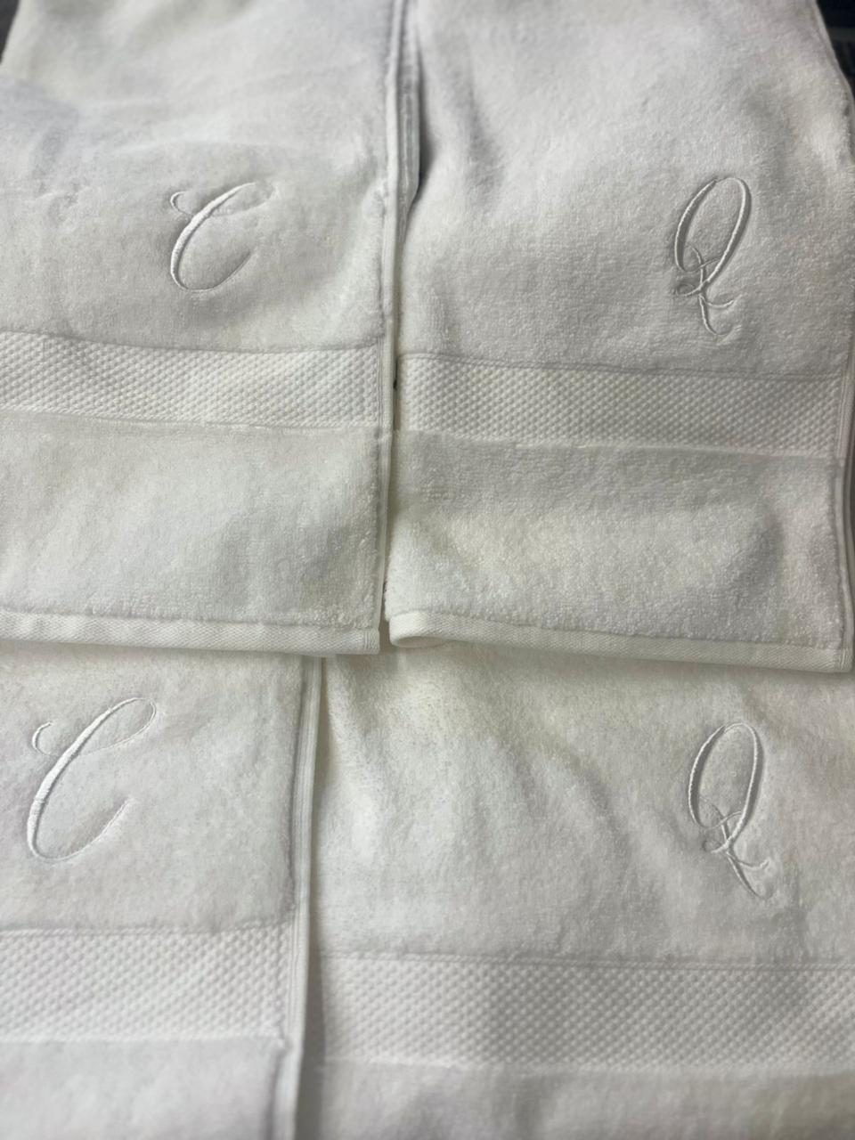 Toalhas de banho dobradas com monogramas bordados em relevo